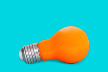 Orange light bulb isolated on blue background