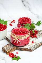 red currant jam with fresh berry. Canned berries on a light background. Food recipe background. Close up
