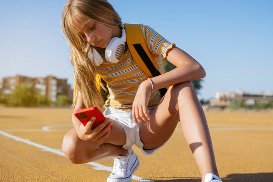 Girl browsing smartphone on playground