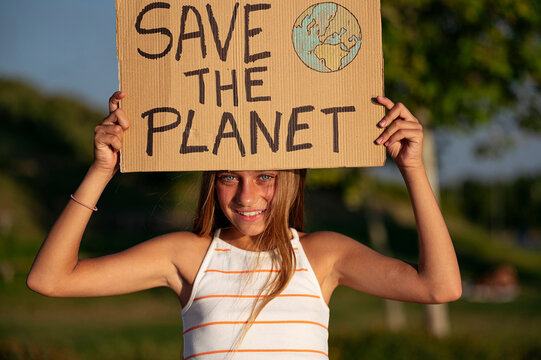 Girl With Save The Planet Sign On Street Park