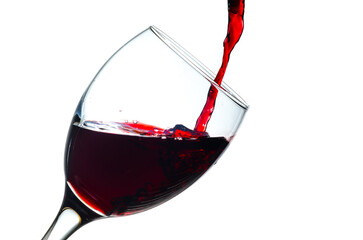 Pouring red wine into a glass isolated on white background
