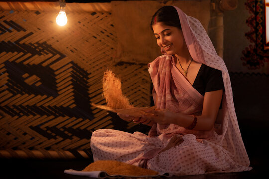 Portrait of Bihar woman cleaning paddy seeds at home