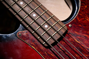Metallic volume treble guitar bass knobs. Electric guitar. Red electric bass guitar close-up. Musical instrument. Music. Four strings. Grif.