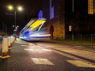 Obraz premium city tram departure from tram station in the night city. urban public transportation