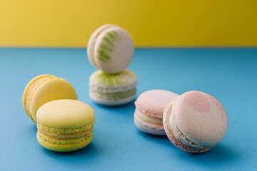 Sweet and colorful macaroons on blue with yellow background