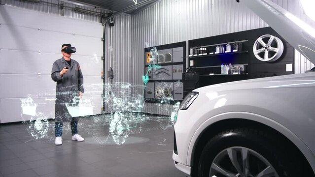 mechanic, a man in a car service checks the car during diagnostics in virtual reality headsets. The concept of modern diagnostics and new technologies for car repair.
