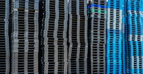 Pile of plastic shipping pallet. Industrial plastic pallet stacked at factory warehouse. Cargo and shipping concept. Plastic pallet rack for export delivery industry. Plastic pallet storage warehouse.