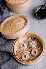 Chinese dumplings being steamed on the traditional bamboo pan
