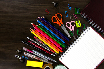 books with color pencils and education elements, back to school concepts on dark wood background