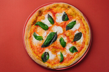 Pizza margarita on red plate and red background