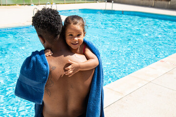 Cute kid hugging anonymous father near outdoor pool