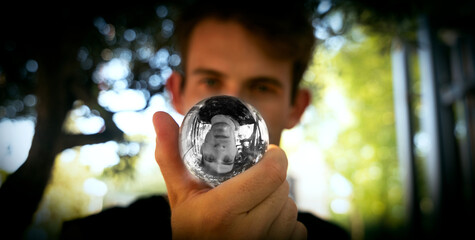 portrait of man holding a crystal ball with its reflection upside down