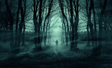 man on dark forest road at night, horror halloween landscape - 523780194