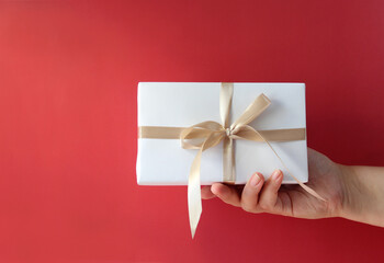 Top view of female hands holding present box package flat lay background copy space for design.