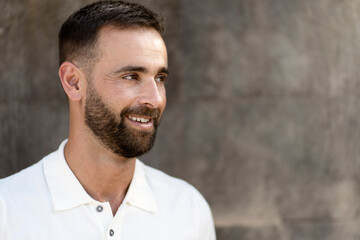 Handsome smiling hispanic man with stylish beard looking away isolated on grey background, copy space. Happy confident customer after barbershop service 