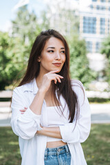 Fototapeta premium Portrait of young asian woman student with long hair in city park
