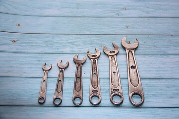 Wrenches isolated on the wooden table, top view, space for text.