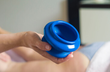 A blue massage can in a woman's hand.