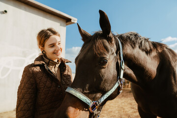 Jockey woman spending time with her horse during equestrian practice