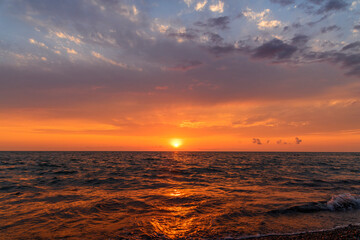 Beautiful sunset over the sea with bright orange clouds.