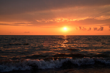 Beautiful sunset over the sea with bright orange clouds.