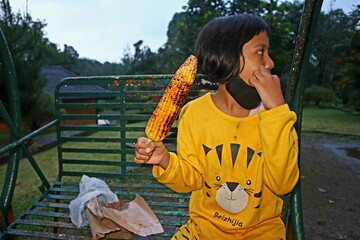 Little girl eating sweet roasted corn