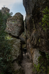 Hiker Passing Through Rocks Along Bear Gulch Trail In Pinnacles