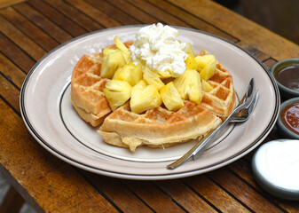 Belgium waffles with pineapple fruit and ice cream on a plate