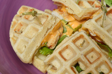 Belgium waffles with greens on purple plate isolated on white background