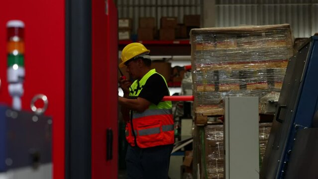 Security guard working at night. Senior asian male security working with flashlight at larg warehouse factory.