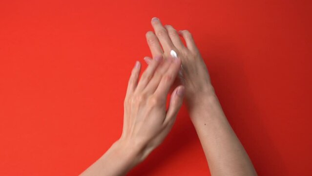 Peron spreading hand cream skincare on hands on a colorful background dermatology 