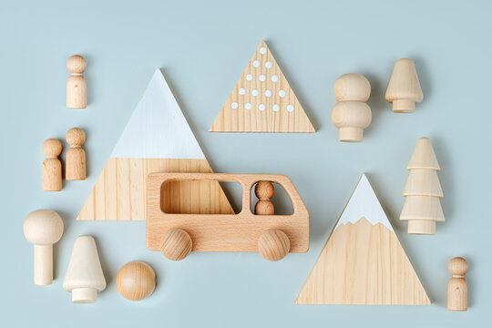 Wooden play set forest, mountains and a bus on a blue background. Games for learning and development of the child. Cute kids toys  for decorating children's room.