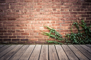 Brick exterior wall with wood floor and creepy green ivy vine.  