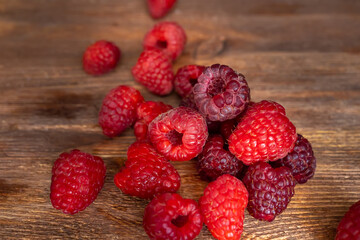 a small bunch of juicy raspberries on a wooden table