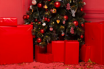 Close-up of colored red large gifts under the decorated beautiful Christmas tree no people