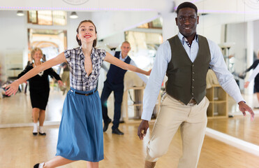 Naklejka premium Woman with african man practising charleston dancing