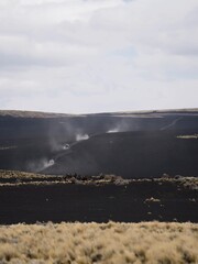 cars driving in mountains and black earth landscape