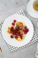 Hot cheesecakes with berries and green tea on concrete background ror breakfast. Top view.