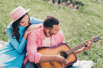 Photo of shiny cute two people together wear casual outfits playing guitar sitting checkered blanket outside garden