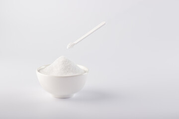Sugar substitute, Stevia in a white plate and in a small spoon. On a white background, a plate with a sugar substitute.
