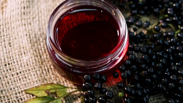 Close-up Freshly squeezed black elderberry juice. Fresh elderberry on an old wooden table