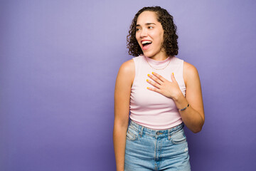 Excited woman looking towards copy space in a studio