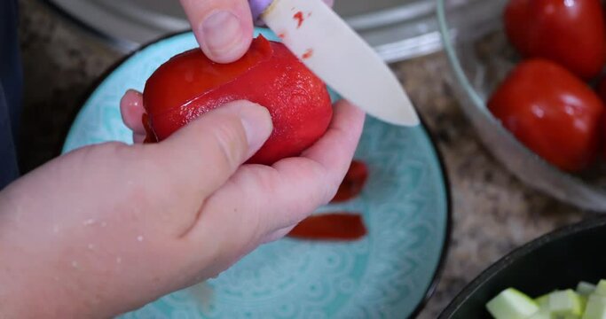 Peeling off the skins of red tomatoes.