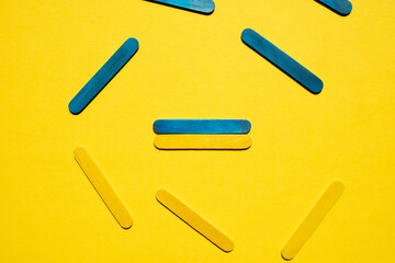 Colored sticks on a yellow background. Ukrainian flag