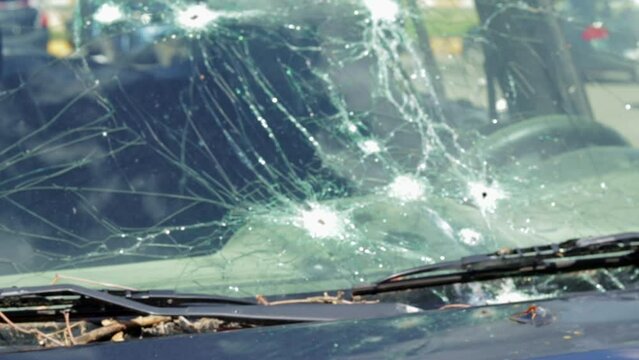 Bullet hole in a car door. Abandoned car with bullet holes. A destroyed vehicle in a war zone in Ukraine. Damaged civilian car. The car was damaged by shrapnel as a result of hostilities.