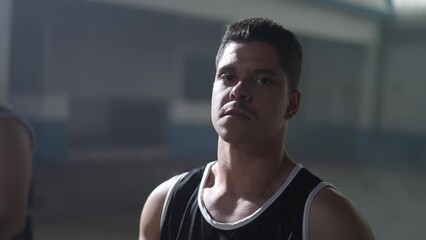 Portrait of a South American hispanic man wearing sportwear looking at camera with dramatic lighting with serious expression