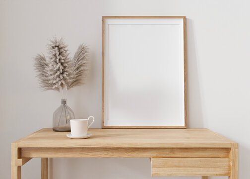 Empty vertical picture frame standing on wooden table in modern living room. Mock up interior in minimalist, contemporary style. Free, copy space for your picture. Vase, pampas grass. 3D rendering.