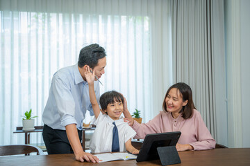 Little boy taking online class with parents helping him at home.