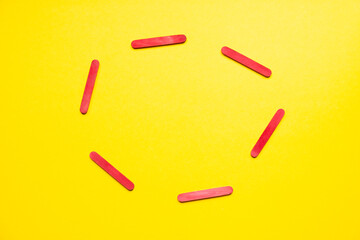 circle of red sticks on a yellow background. Place for important information