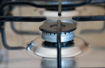 Close-up of a gas stove with no gas flowing out of it. The oven is turned off. The flame has gone...